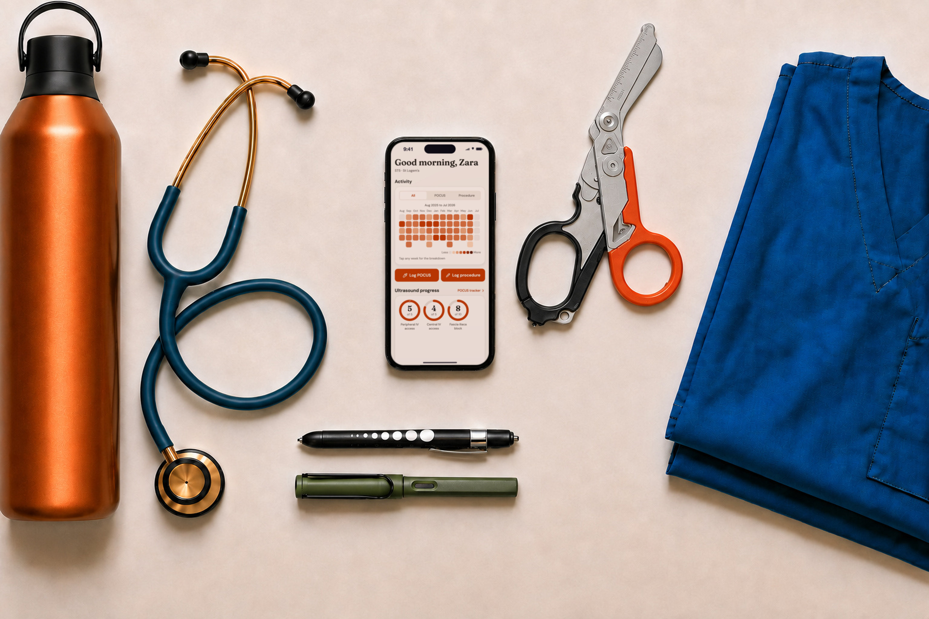Emergency department shift essentials arranged around a phone running LogEM: stethoscope, trauma shears, pen torch, water bottle and scrubs